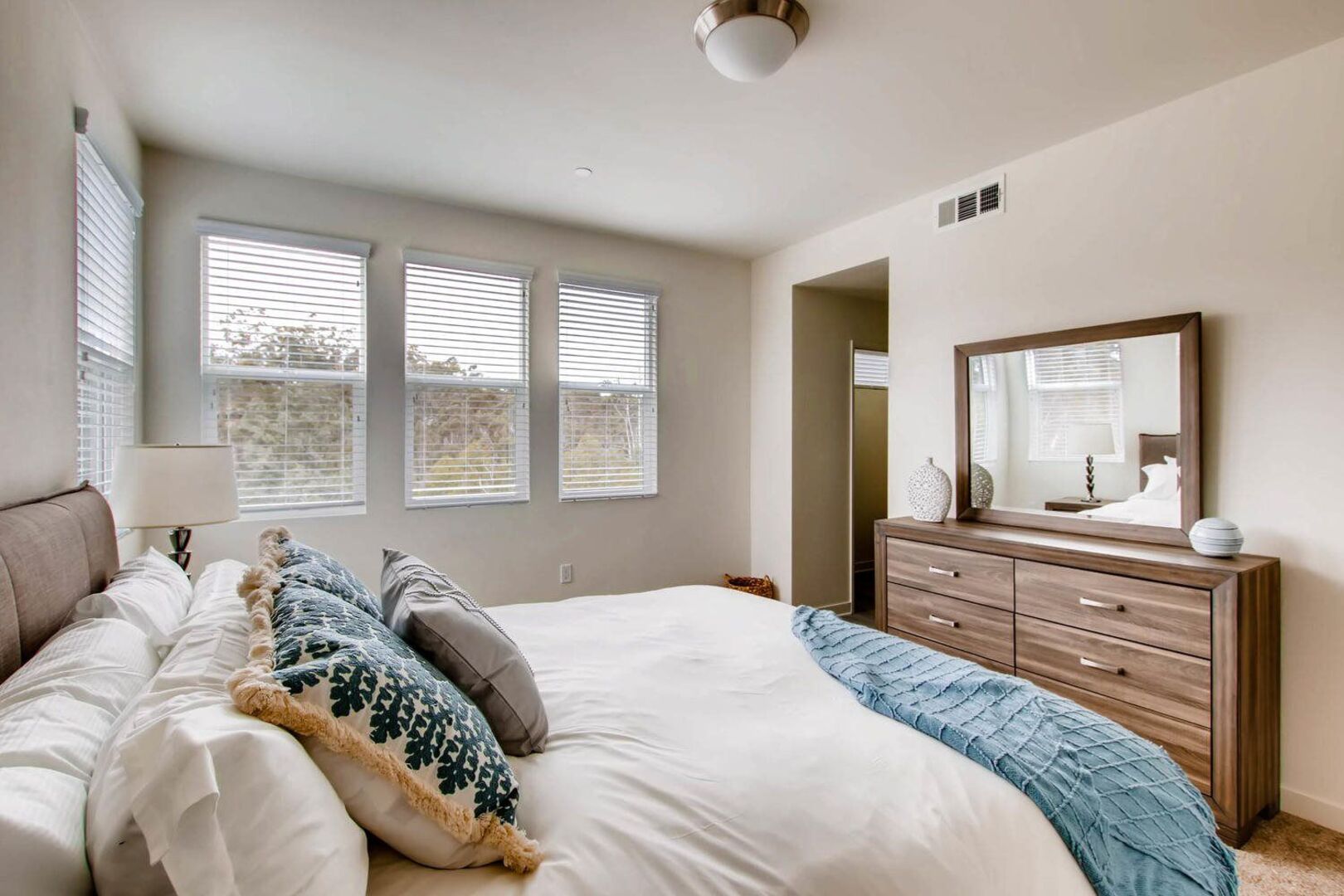 staged bedroom with multiple windows and private bathroom