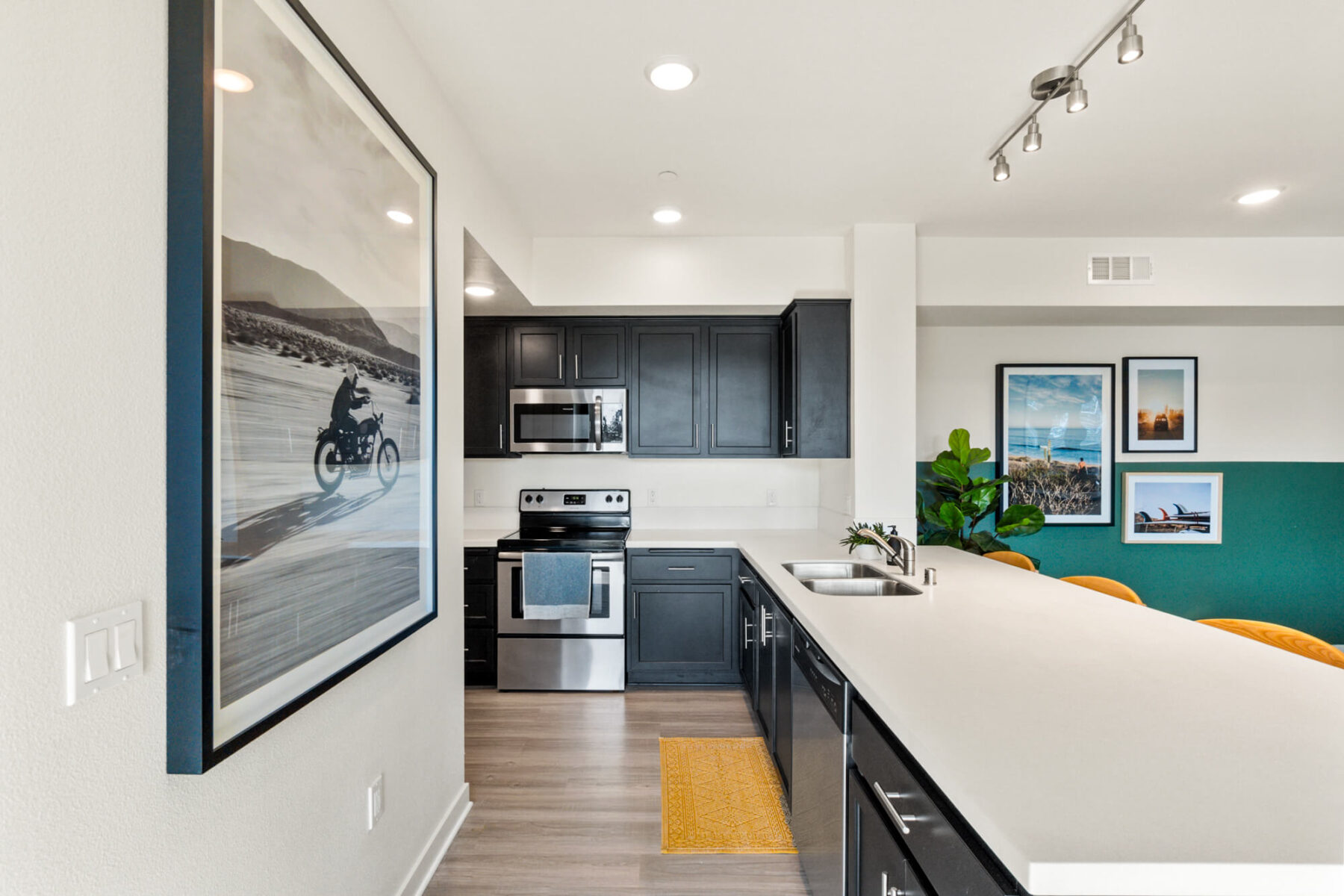 Kitchen with white counters, black cabinets, and stainless steel appliances
