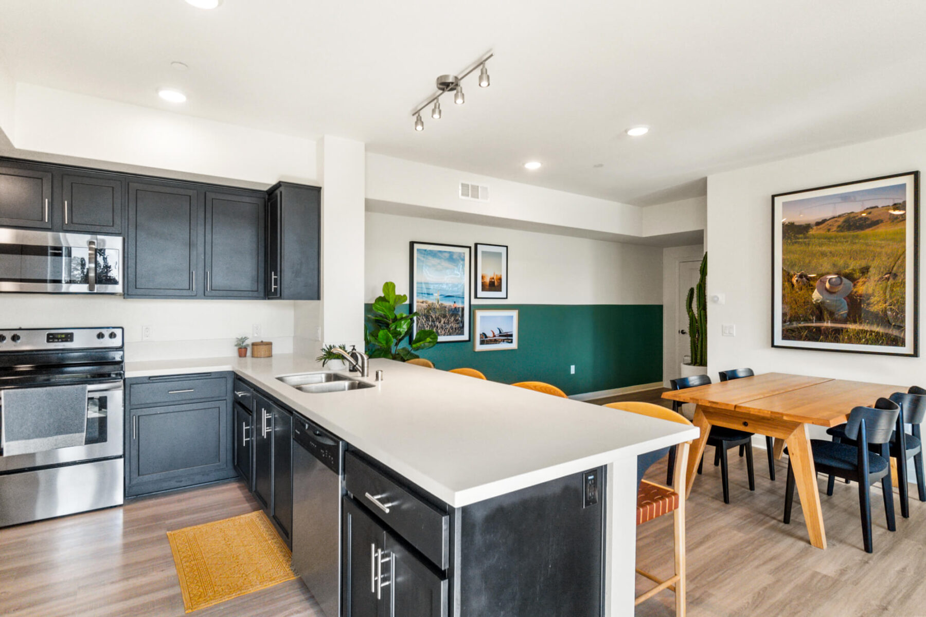 Kitchen with white counters and bar seating looking into the dining area