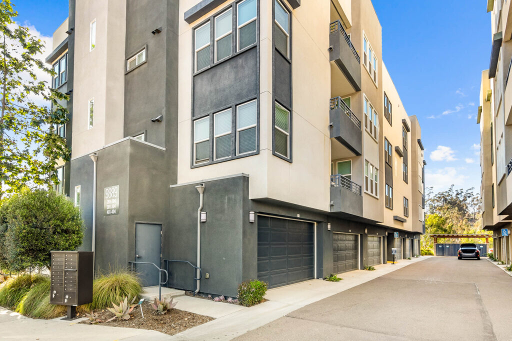 Building exterior showing garages, balconies, and mailboxes