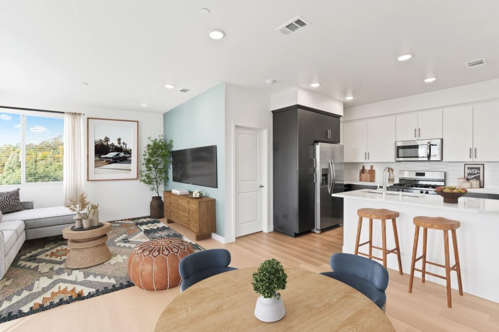 Dining room with open entry to kitchen and living room, wood-style flooring, designer lighting, and dining table seating