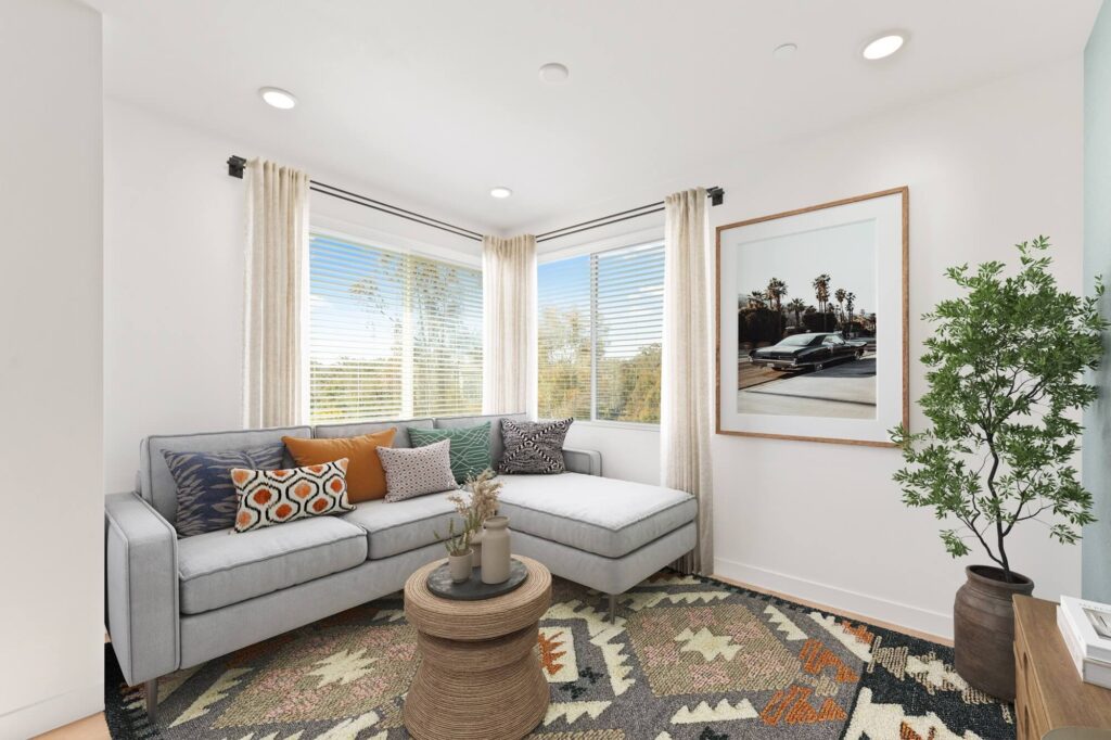 Living room with wood-style flooring, wall decor, designer lighting, windows, and couch seating