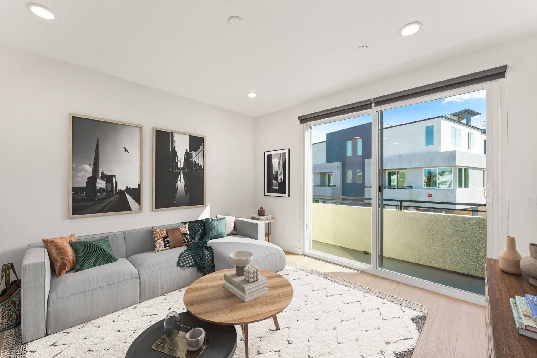 Living room with wood-style flooring, wall decor, designer lighting, and sliding door to balcony